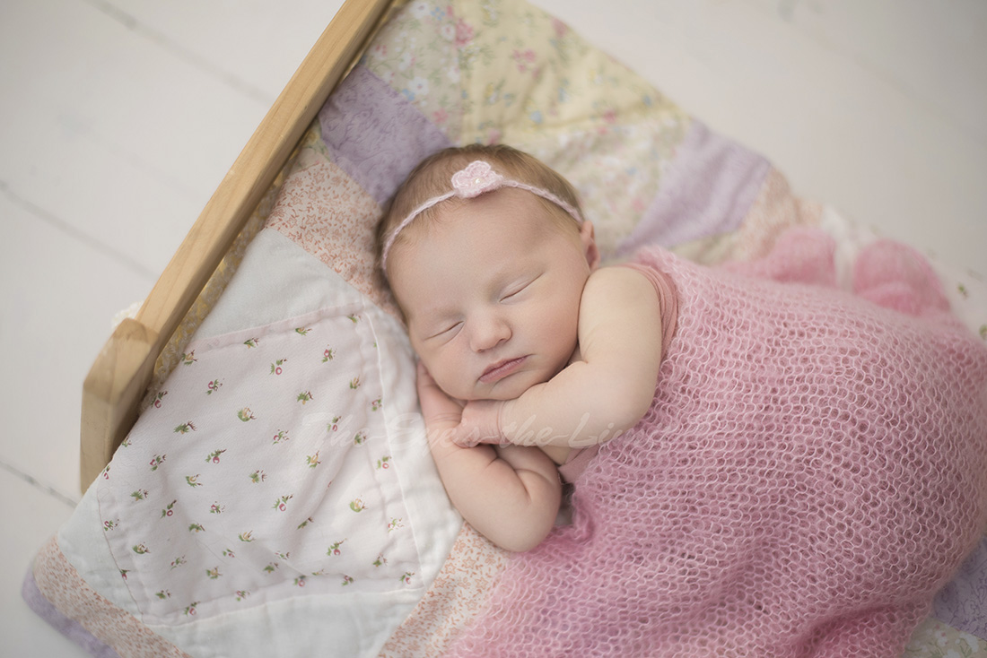 Newborn baby sleeping in doll bet